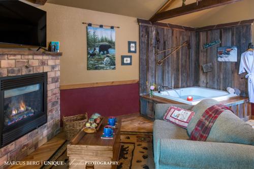 a living room with a fireplace and a tub at Eureka Sunset Cabins in Eureka Springs