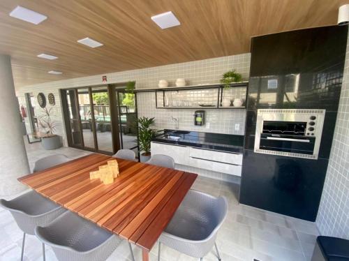 eine Küche mit einem Holztisch und einigen Stühlen in der Unterkunft Studio luxuoso para 4 hóspedes! ler descrição in Maceió