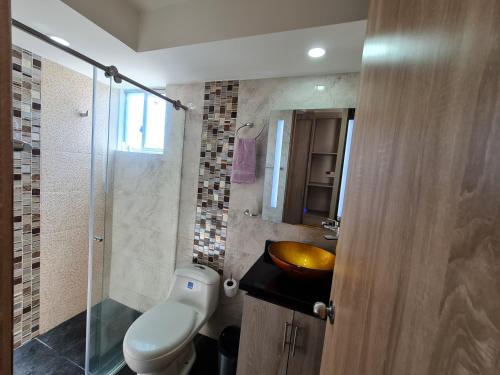 a bathroom with a toilet and a sink and a shower at Confortable apartamento en conjunto Puerto Azul Club House in Ricaurte