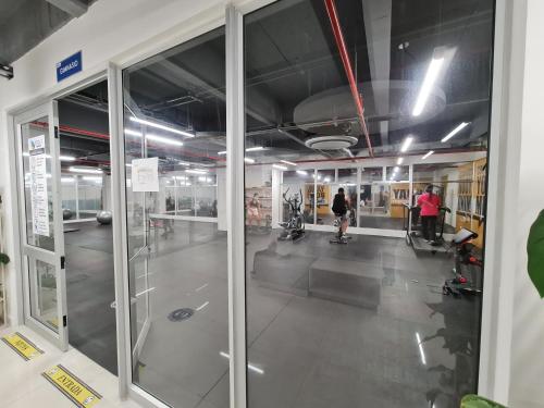 a gym with glass doors and people in a room at Confortable apartamento en conjunto Puerto Azul Club House in Ricaurte