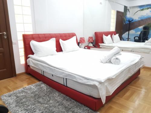 2 camas en una habitación con marco de cama rojo en Lights Spa National Arena Mega Mall Monza, en Bucarest