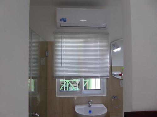 baño con lavabo blanco y ventana en Cozy Studios-Private Entrance- HS Internet-AC-Hot Water-Backup Generator-near the Beach, en San Felipe de Puerto Plata