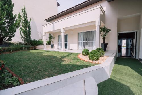 a house with a lawn in front of it at Prosper Executive Hotel in Capivari