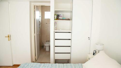 1 dormitorio con paredes blancas, 1 cama y baño en Apartment in Recoleta Buenos Aires next to an Embassy en Buenos Aires
