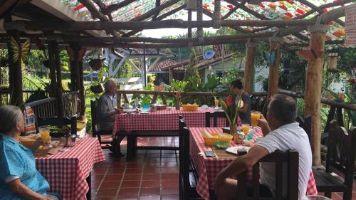 a group of people sitting at tables in a restaurant at Villa Luzandi in Quimbaya