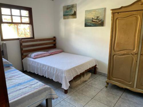 a small bedroom with a bed and a dresser at Casa aconchegante - Búzios in Búzios