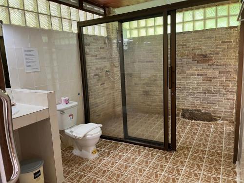 a bathroom with a toilet and a glass shower at Plaa's Thansadet Resort in Than Sadet Beach