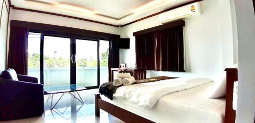 a bedroom with a bed and a table and window at EZ House in Sukhothai