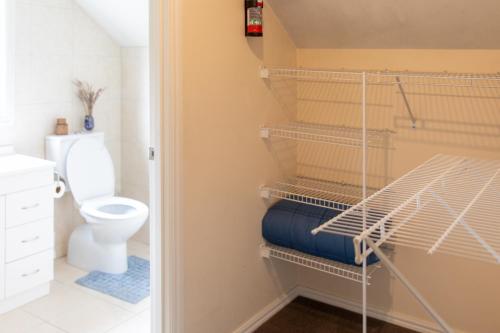 a bathroom with a toilet and a bed in a room at The Loft at Sixty-7 in Queenstown