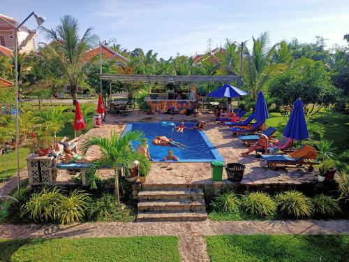 eine Gruppe von Personen in einem Pool in einem Resort in der Unterkunft Karma Traders Kampot in Kampot