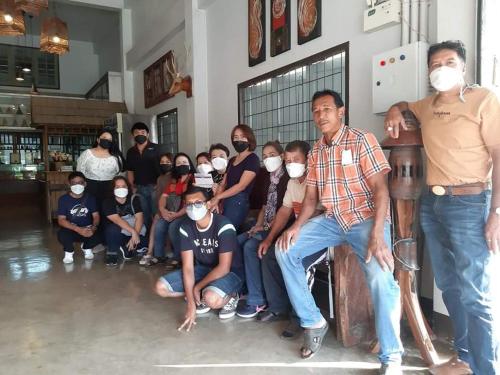 a group of people wearing masks in a room at EZ House in Sukhothai
