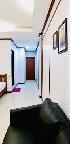 a living room with a black couch in a room at EZ House in Sukhothai