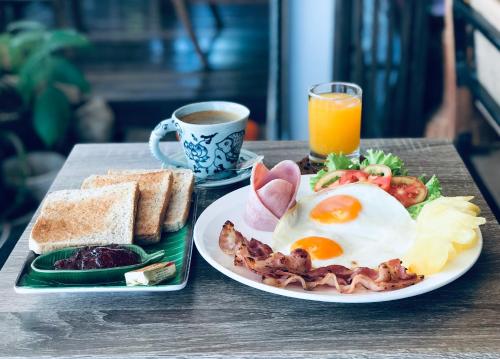 a breakfast plate of eggs bacon and toast and a cup of coffee at EZ House in Sukhothai