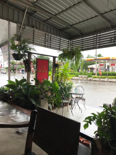a patio with a table and chairs and plants at EZ House in Sukhothai