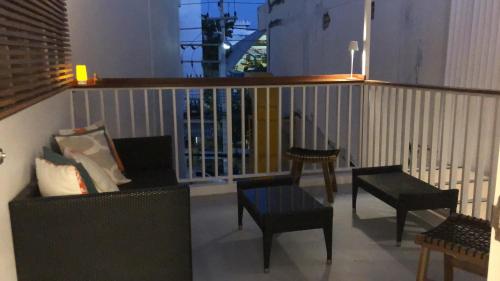 d'un balcon avec un canapé, des chaises et une balustrade. dans l'établissement Yellow door Hua Hin, à Hua Hin
