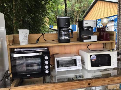 uma prateleira com micro-ondas e electrodomésticos em 山旅民宿 em Meishan