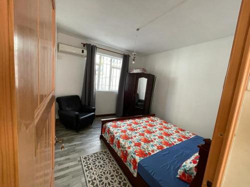 a bedroom with a bed and a chair in it at Green bay 2 in Pereybere