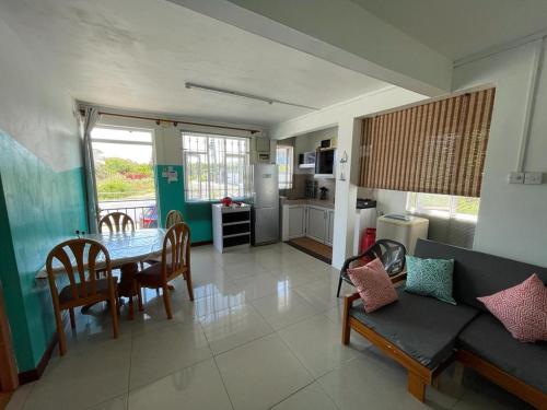 a living room with a couch and a table with chairs at Green Bay Villa in Pereybere