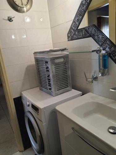 uma casa de banho com uma máquina de lavar roupa e um lavatório em CityHome2 em Lárissa