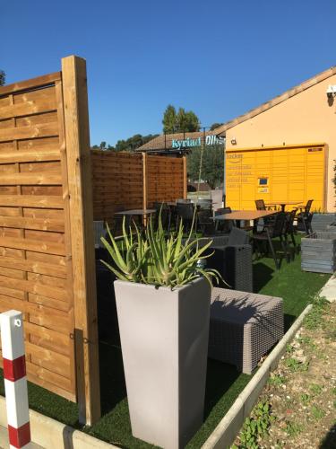 a garden with a fence and a potted plant at Kyriad Direct Marseille Est La Valentine in La Penne-sur-Huveaune