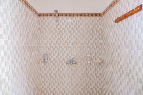 a bathroom with a shower with pink tiled walls at The Bingin Green View by Bukit Vista in Uluwatu