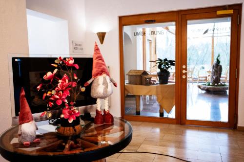 a room with two gnomes sitting on a glass table at DAS LOFT Hotel Hölsterloh in Brilon