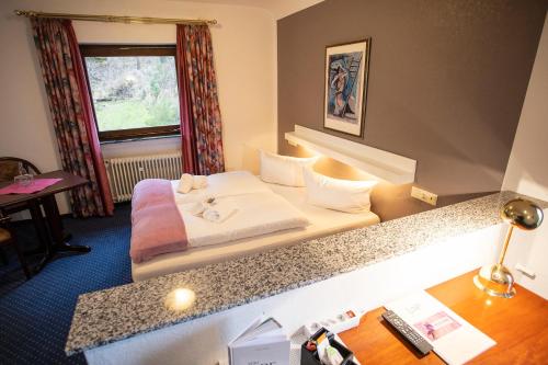 a hotel room with a bed and a desk at DAS LOFT Hotel Hölsterloh in Brilon