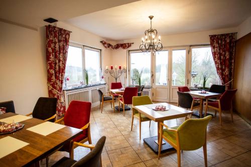 a restaurant with tables and chairs and windows at DAS LOFT Hotel Hölsterloh in Brilon
