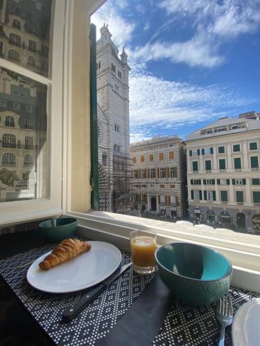a table with a plate of food and a window at New Apartament in front of Genoa Cathedral in Genova