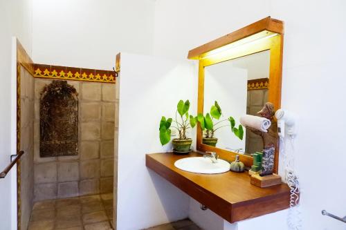 a bathroom with a sink and a mirror at D'omah Yogya Hotel in Yogyakarta