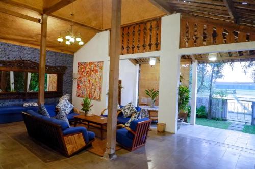 a living room with blue chairs and a table at D'omah Yogya Hotel in Yogyakarta
