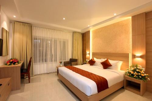 una camera d'albergo con letto e scrivania di RAAS Residency a Cochin