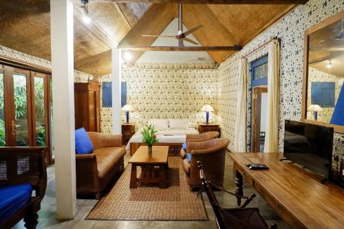 a living room with a couch and a tv at D'omah Yogya Hotel in Yogyakarta