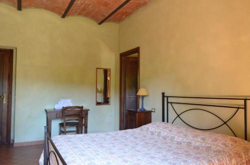 a bedroom with a bed and a table and a chair at Tenuta Agricola dell'Uccellina in Talamone