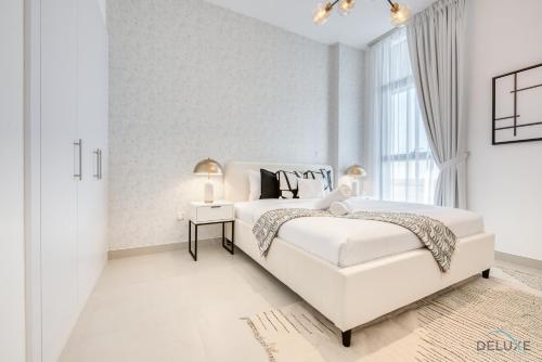 A bed or beds in a room at Alluring 1BR at The Pulse Blvd C3 Dubai South by Deluxe Holiday Homes