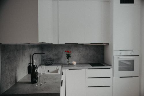 a white kitchen with white cabinets and a sink at Apartman PENNY in Zvolen