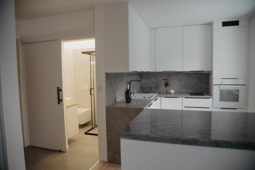 a kitchen with white cabinets and a counter top at Apartman PENNY in Zvolen