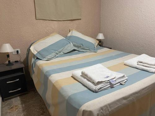1 dormitorio con 1 cama grande y toallas. en Departamentos - del TALAMPAYA en Villa Unión
