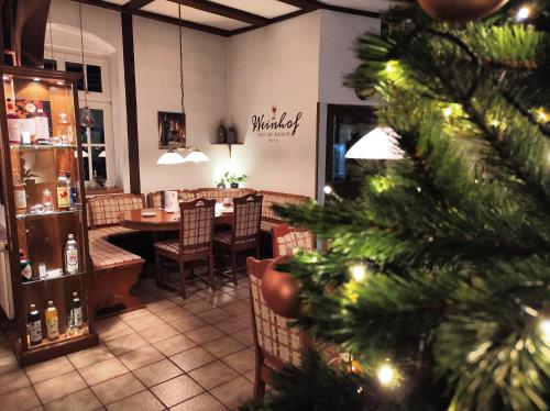 a christmas tree in a restaurant with a dining room at Hotel Weinhof Groß Mackenstedt in Stuhr