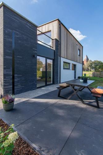 a picnic table in front of a house at Villa veld en velo in Bree