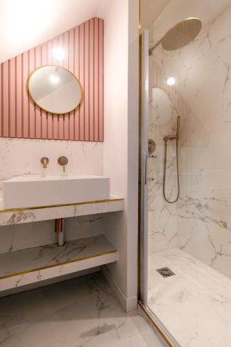 a bathroom with a sink and a shower at Studios Le Medicis vue Seine in Belbeuf