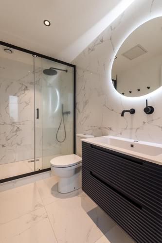 a bathroom with a toilet and a shower and a sink at Studios Le Medicis vue Seine in Belbeuf