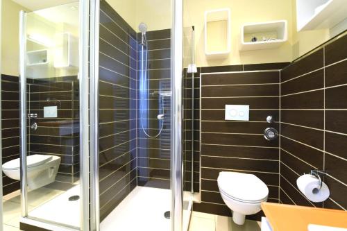 ein Bad mit einem WC und einer Glasdusche in der Unterkunft Exklusives Ferienhaus mit Schwimmbad und Sauna in Grömitz