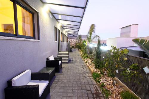 a walkway with benches and plants on a building at Achuza Bamarom in Safed