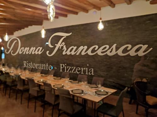 a dining room with a long table in front of a wall at Don Vittorio Country Village in Taormina