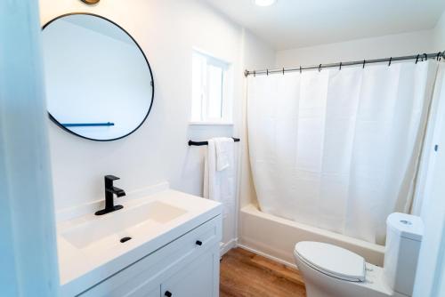 Baño blanco con lavabo y espejo en Tidal House #10 - Ocean Shores Chalet en Ocean Shores