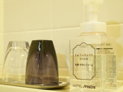 a bottle of soap and a vase on a shelf at Hotel AreaOne Takamatsu City in Takamatsu