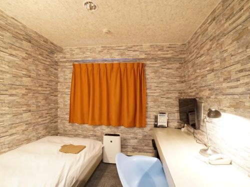 a bedroom with two beds and an orange curtain at Hotel AreaOne Takamatsu City in Takamatsu