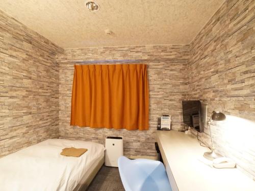 a bedroom with two beds and an orange curtain at Hotel AreaOne Takamatsu City in Takamatsu