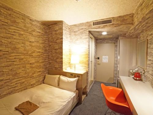 高松市にあるホテルエリアワン高松シティのベッドとデスクが備わるホテルルームです。